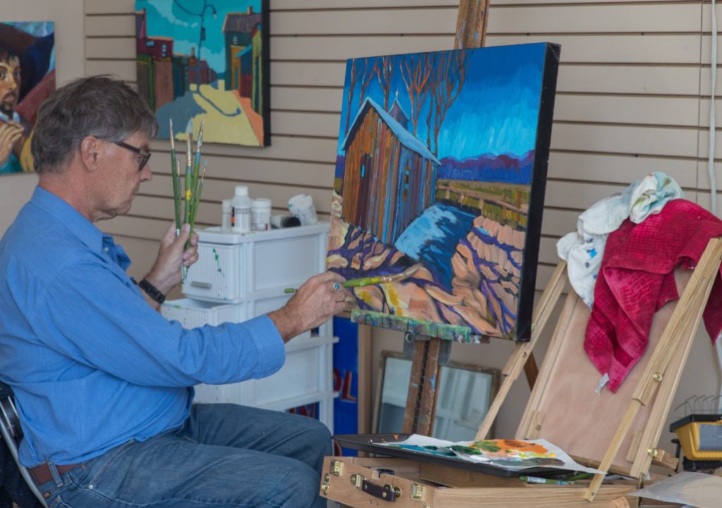 Photo of Strachan painting at his studio in Almonte Ontario The artist at work in his studio